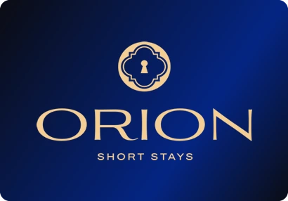 Orion Short Stays logo: A gold quatrefoil badge with a keyhole, above a wide gold wordmark.